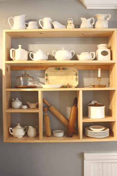 Wooden DIY wall shelf mounted on wall with kitchen items displayed on it