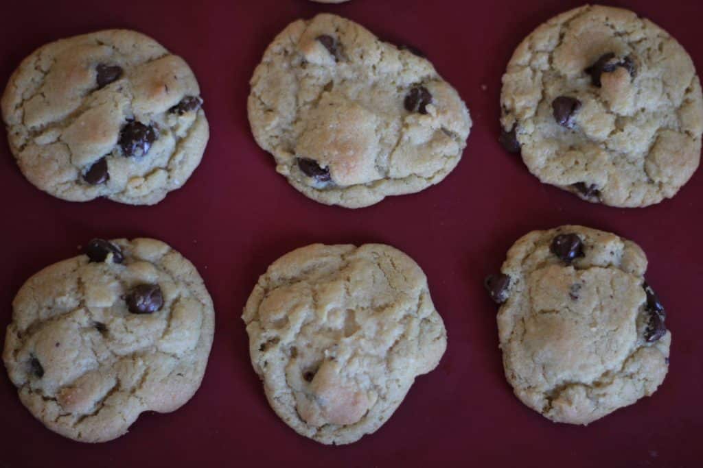 baked chocolate chip cookies on red silicone baking mat