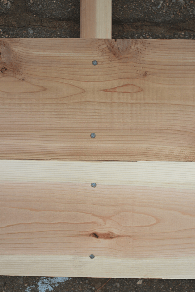 two cedar boards nailed into square baluster with four nails