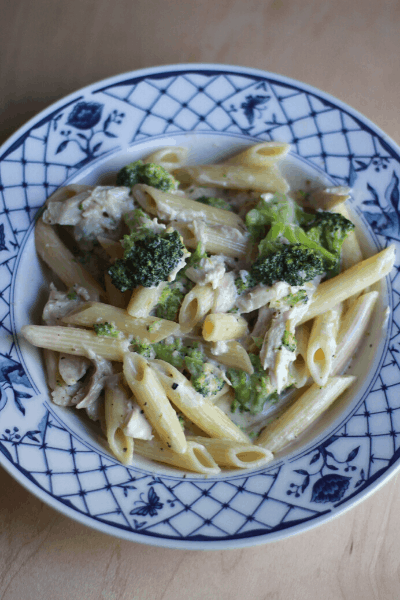 chicken broccoli alfredo pasta in a blue and white bowl