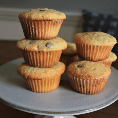 the ultimate chocolate chip muffins stacked on top of each other on a cake stand