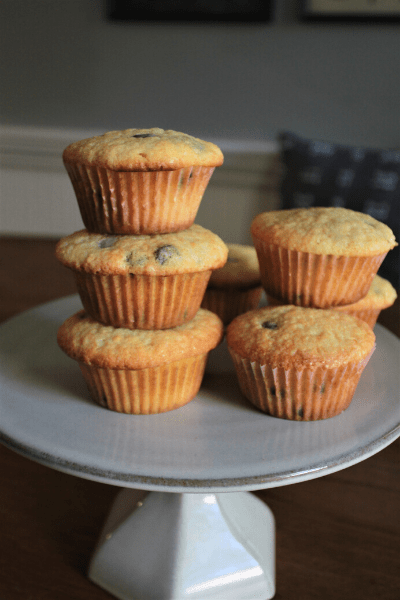 the ultimate chocolate chip muffins stacked on top of each other on a cake stand
