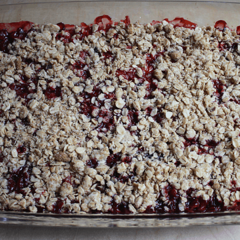 homemade strawberry and blueberry crisp in a 9x13 glass baking dish