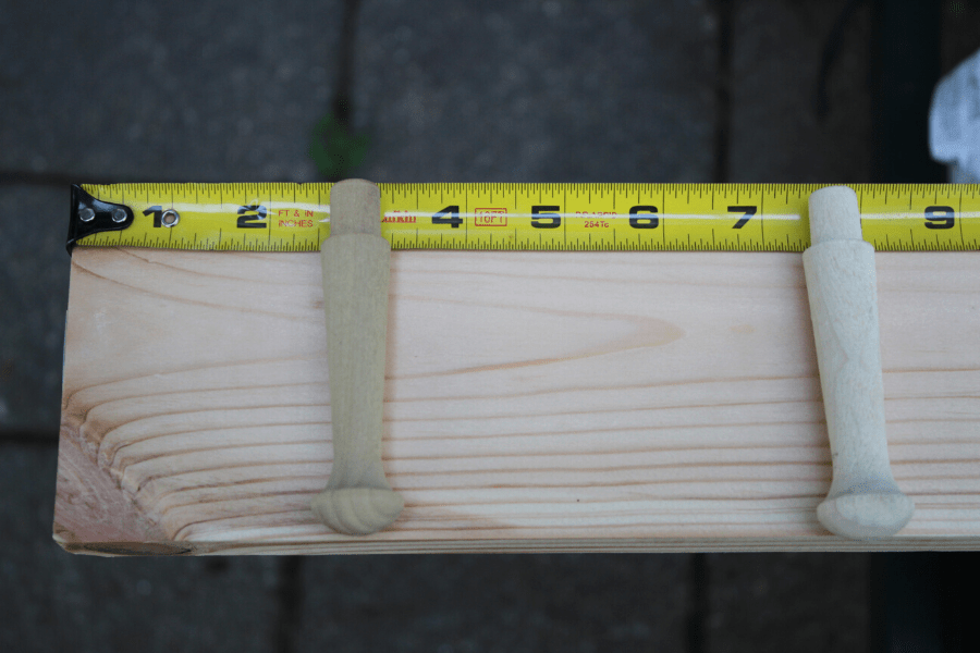 wood pine board with measuring tape laying on top measuring out ever 5 inches where shaker pegs will be drilled in